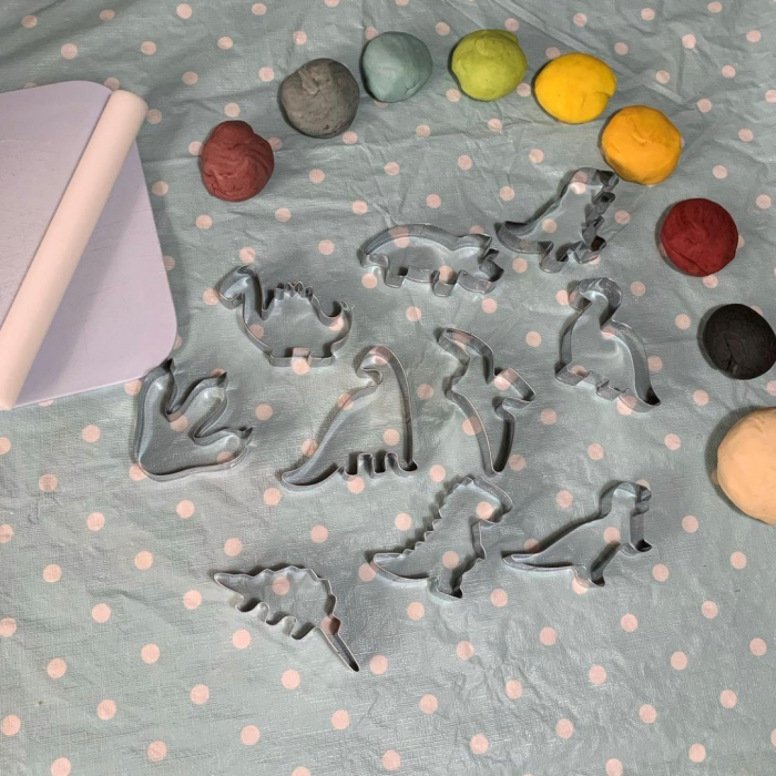 Dinosaur cookie cutters and selection of play dough