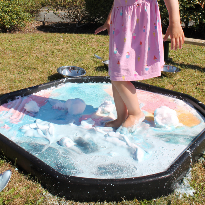 child walking over foam in tuff tray